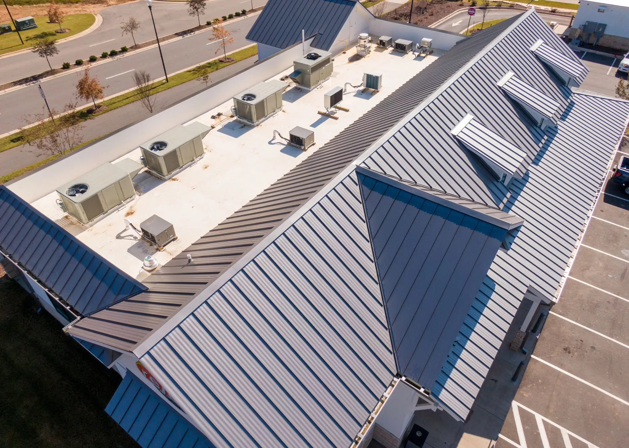 Aerial view of a metal roof with multiple HVAC units installed.