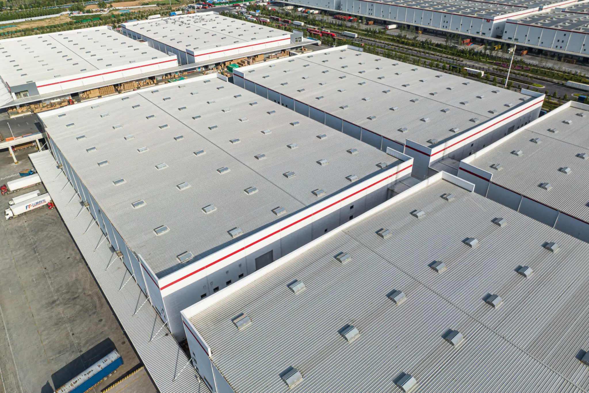 Aerial view of large industrial warehouse roofs with ventilation.
