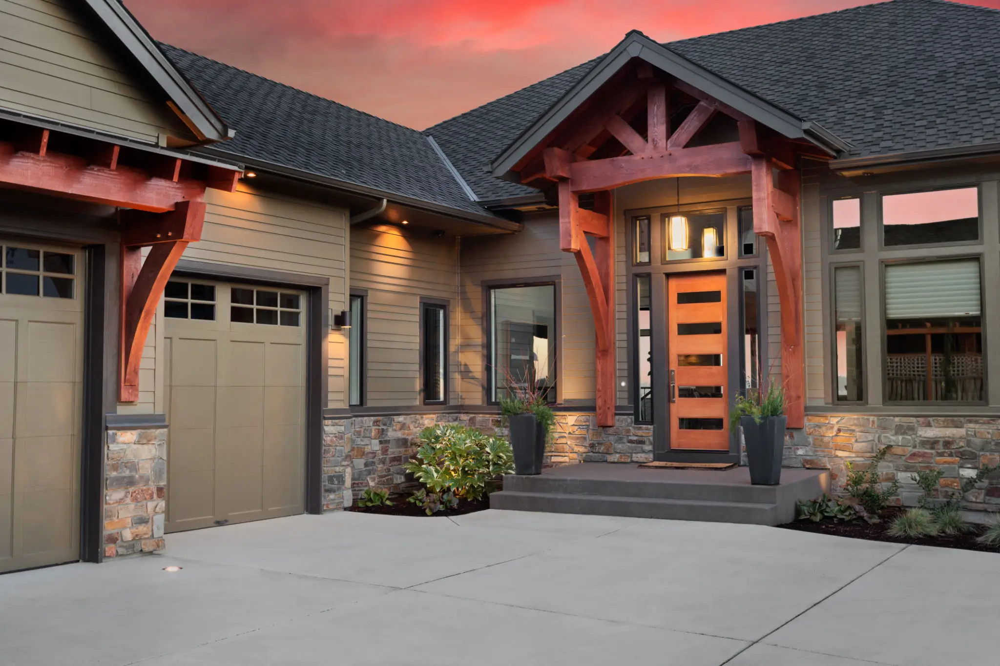 Modern house exterior with warm lighting and a stylish front door at sunset.