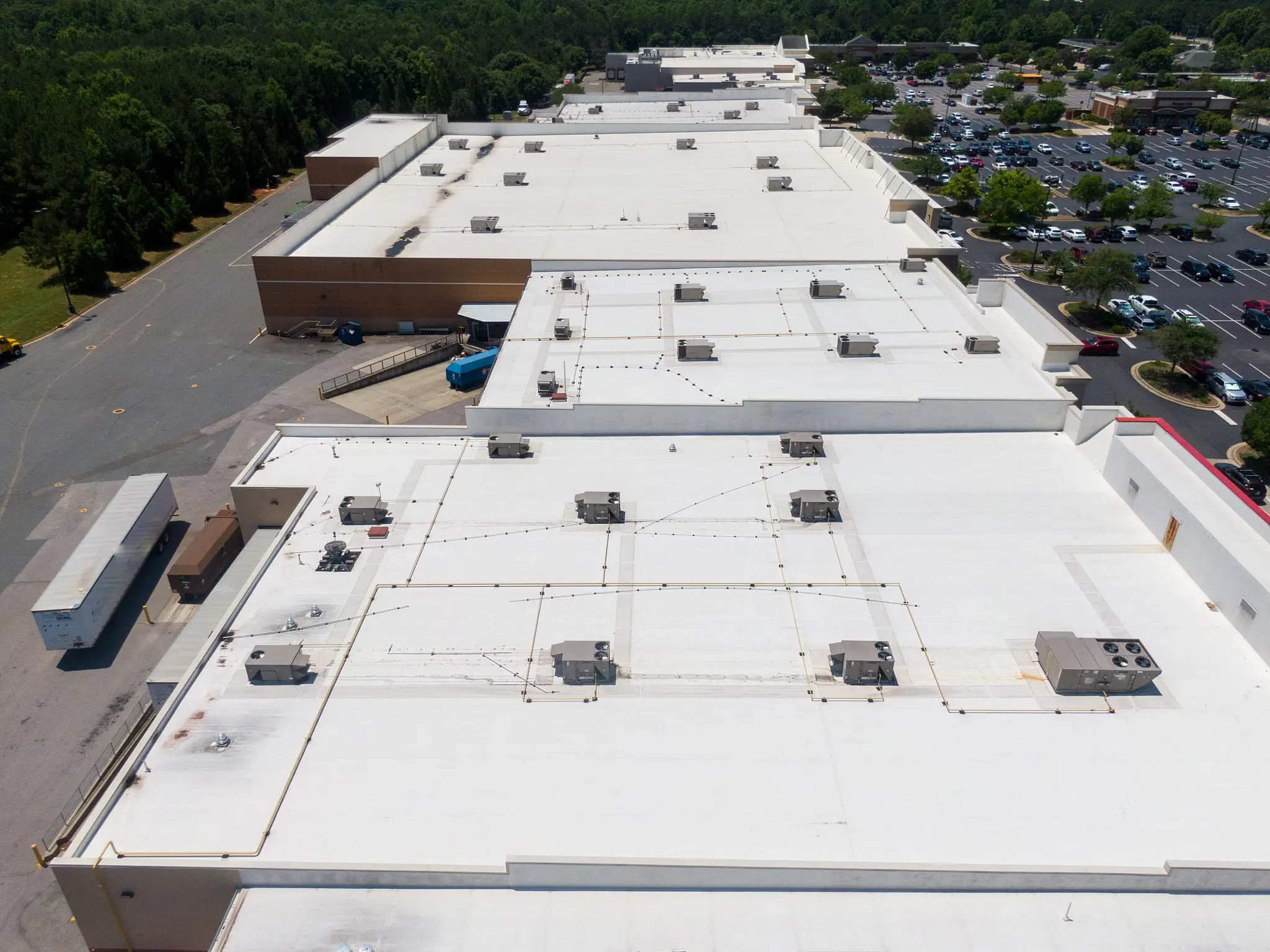 Aerial view of a large white rooftop with multiple HVAC units.