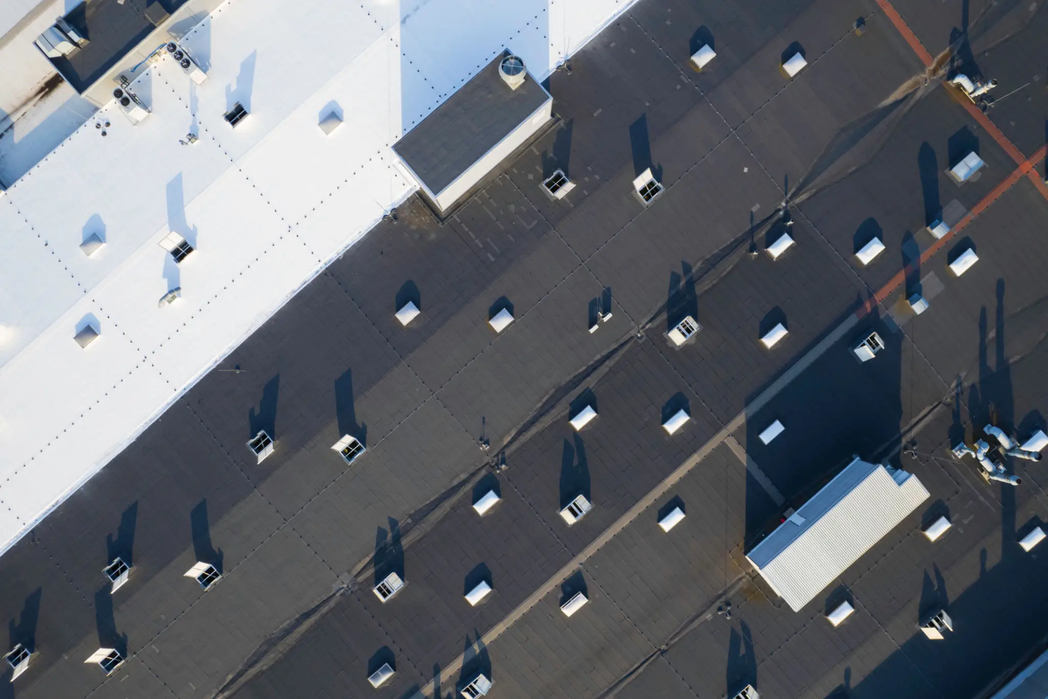 Aerial view of a busy pedestrian street with shadows and people walking.