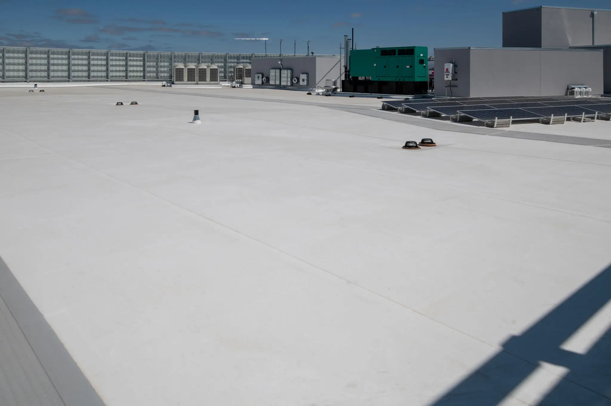 A rooftop with HVAC units and a clear sky.